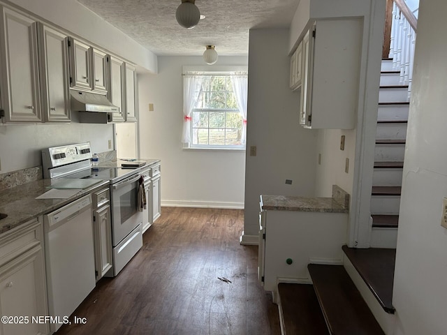 kitchen with white cabinetry, white appliances, dark hardwood / wood-style flooring, and a textured ceiling