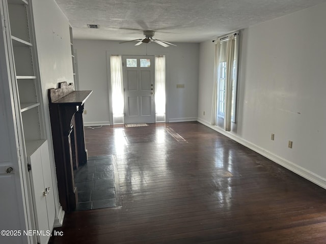 foyer entrance with dark hardwood / wood-style flooring, ceiling fan, and a textured ceiling