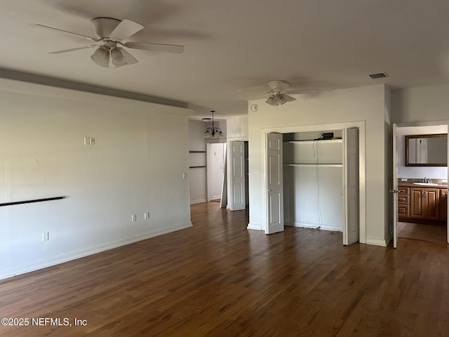 unfurnished bedroom with sink, dark hardwood / wood-style flooring, ceiling fan, ensuite bath, and a closet