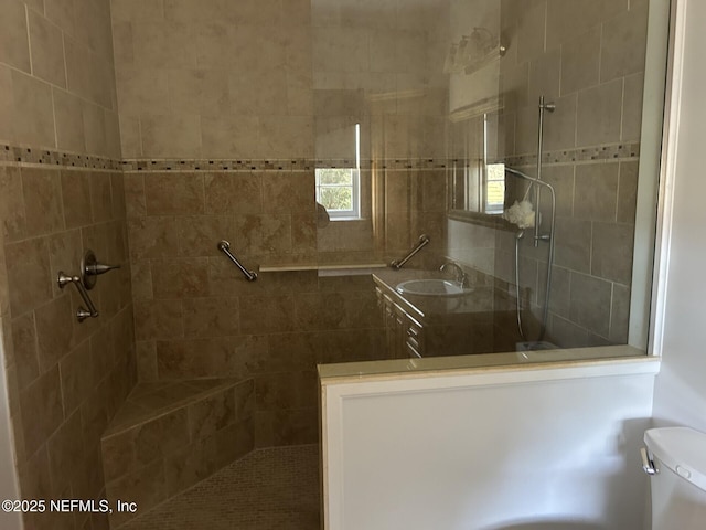 bathroom with tiled shower, toilet, and sink