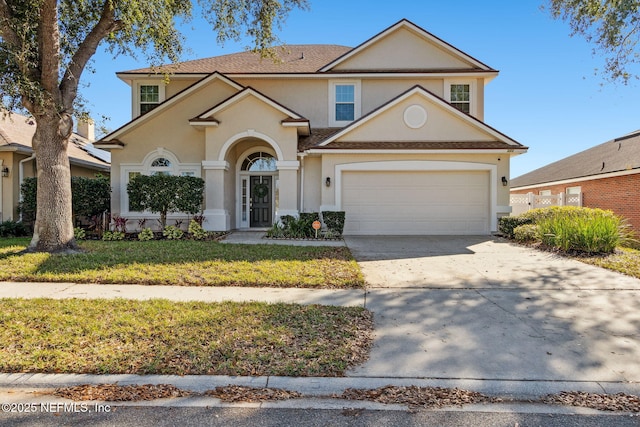 traditional home featuring concrete driveway, a front lawn, and stucco siding