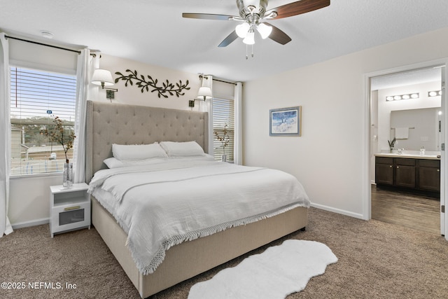 carpeted bedroom with multiple windows, ceiling fan, and ensuite bath