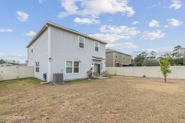 back of house featuring a patio, a yard, and central AC