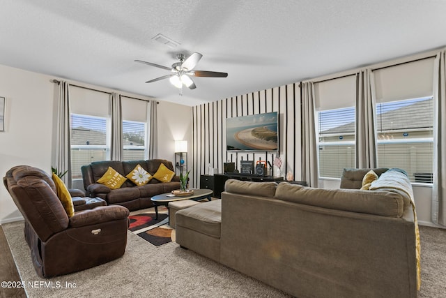 living room featuring ceiling fan, carpet, and a textured ceiling