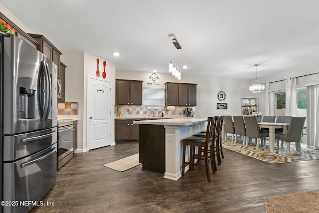 kitchen featuring appliances with stainless steel finishes, a center island, pendant lighting, and a kitchen bar