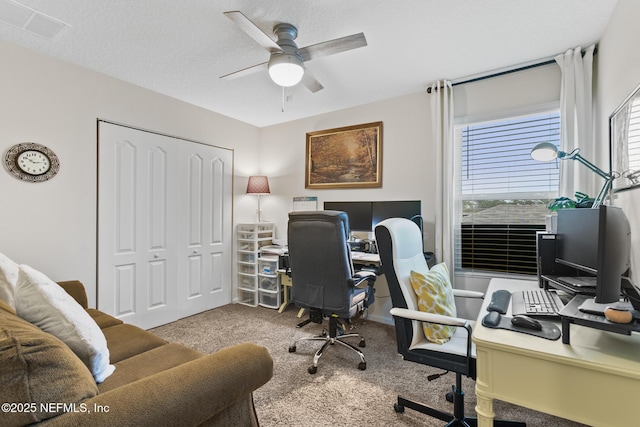 carpeted office space featuring ceiling fan