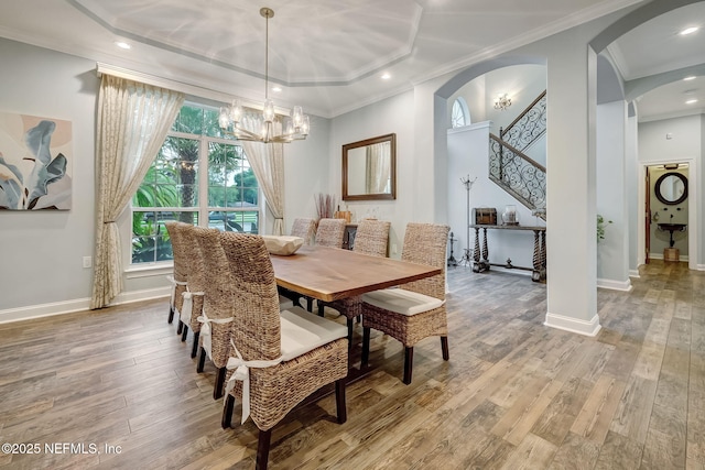 dining space featuring an inviting chandelier, ornamental molding, and light wood-type flooring