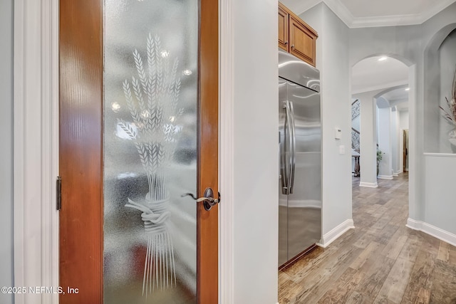 hallway featuring crown molding and light wood-type flooring