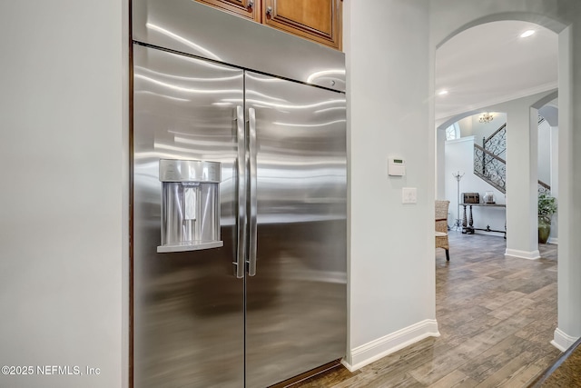 kitchen featuring stainless steel built in fridge and light hardwood / wood-style floors