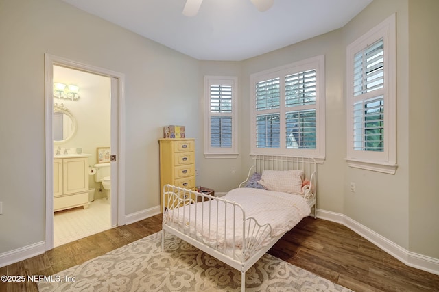 bedroom featuring connected bathroom, sink, hardwood / wood-style flooring, and ceiling fan