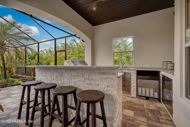 view of patio with area for grilling and a wet bar