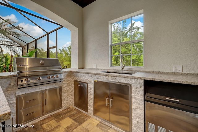 view of patio / terrace featuring an outdoor kitchen, a grill, a lanai, and sink