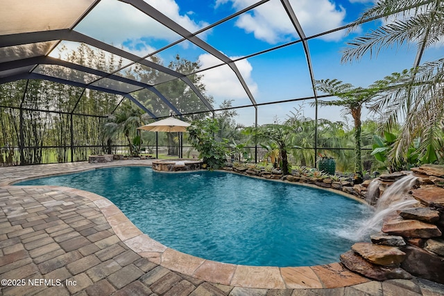 view of pool with an in ground hot tub, pool water feature, a patio, and glass enclosure