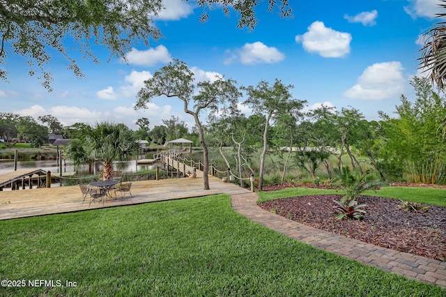 view of yard with a water view and a boat dock