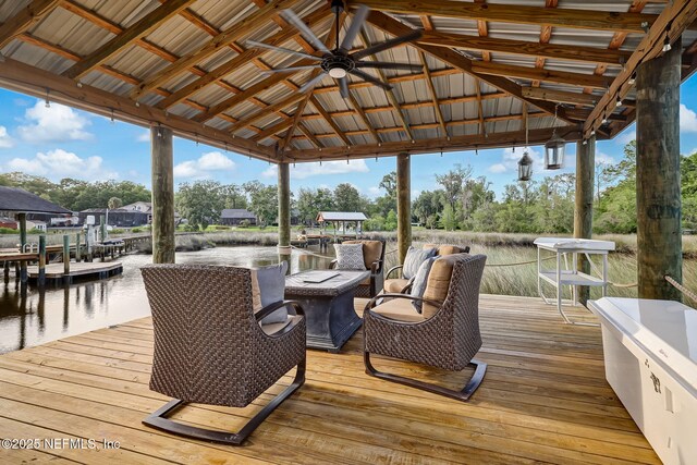 wooden terrace featuring a gazebo, a water view, and a dock