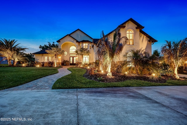 mediterranean / spanish house with a yard and french doors