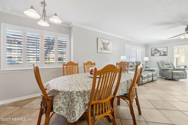 tiled dining room featuring ornamental molding, ceiling fan with notable chandelier, and a textured ceiling