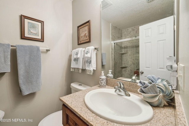 bathroom featuring walk in shower, vanity, toilet, and a textured ceiling