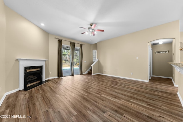 unfurnished living room featuring ceiling fan, a high end fireplace, and dark hardwood / wood-style flooring