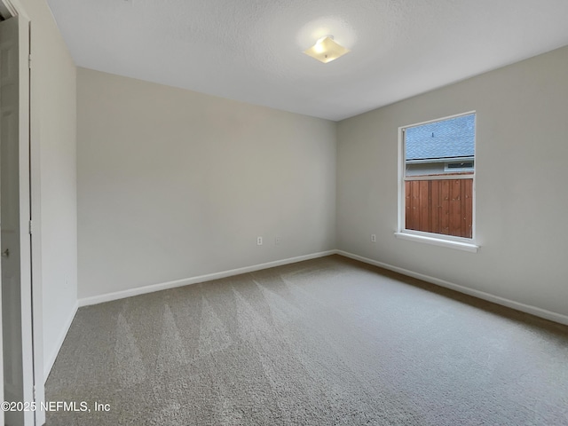 carpeted empty room with a textured ceiling