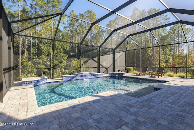 view of swimming pool with pool water feature, glass enclosure, and a patio area