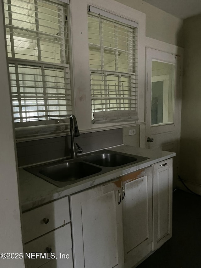 kitchen featuring sink and white cabinets