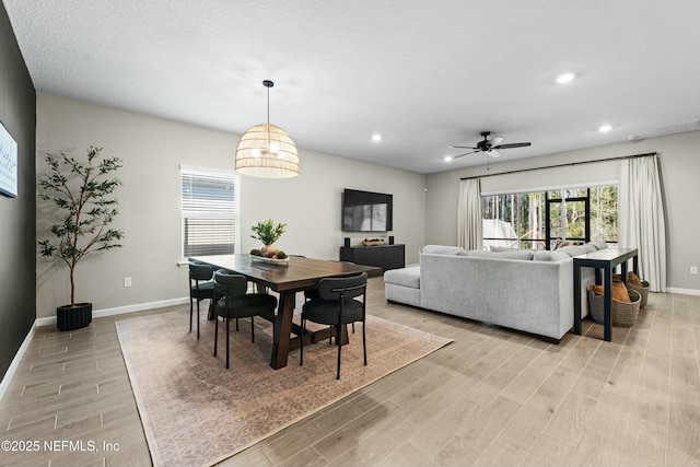 dining room with a textured ceiling, ceiling fan, and light wood-type flooring