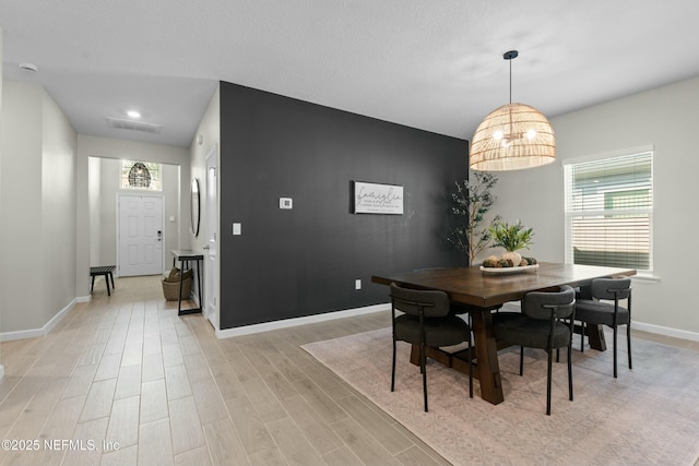 dining space with a notable chandelier and light wood-type flooring