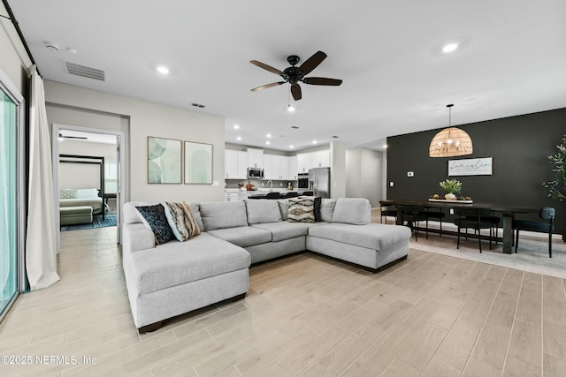 living room featuring ceiling fan and light wood-type flooring