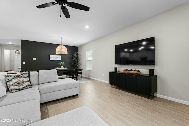 living room featuring light hardwood / wood-style floors and ceiling fan