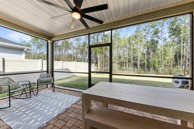 sunroom / solarium with a wealth of natural light, wooden ceiling, and ceiling fan