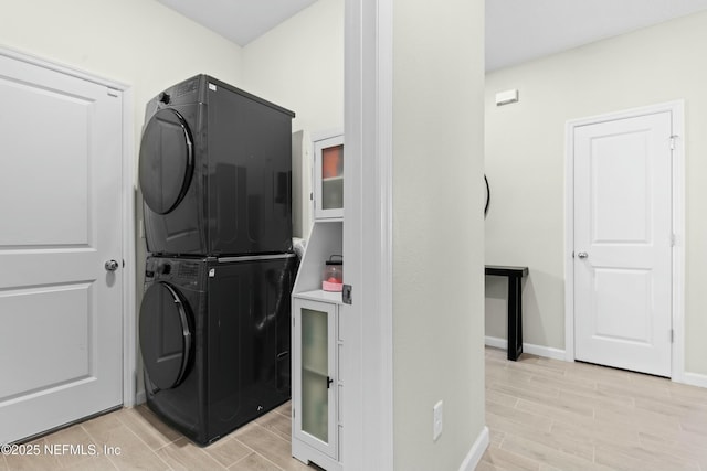 washroom featuring stacked washer and clothes dryer