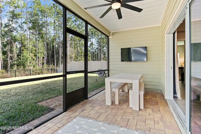 unfurnished sunroom featuring ceiling fan