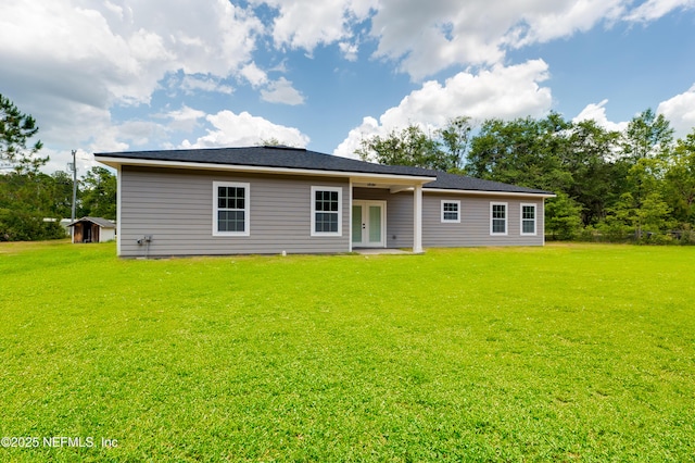 rear view of house featuring a yard