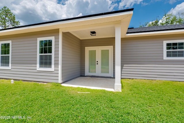 doorway to property with a lawn, a patio area, and french doors