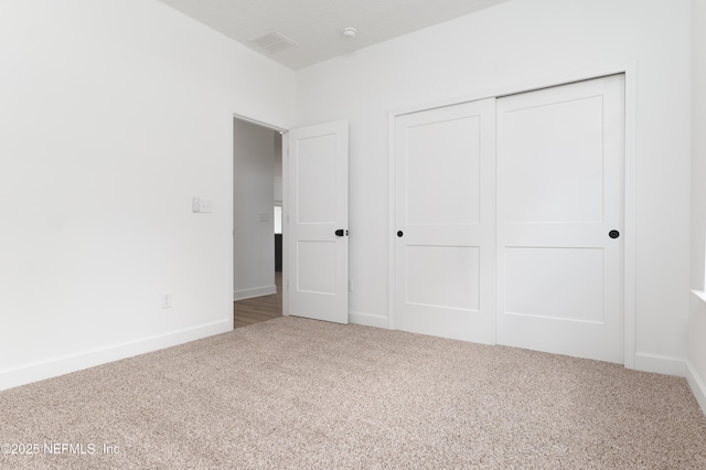 unfurnished bedroom featuring carpet floors and a closet