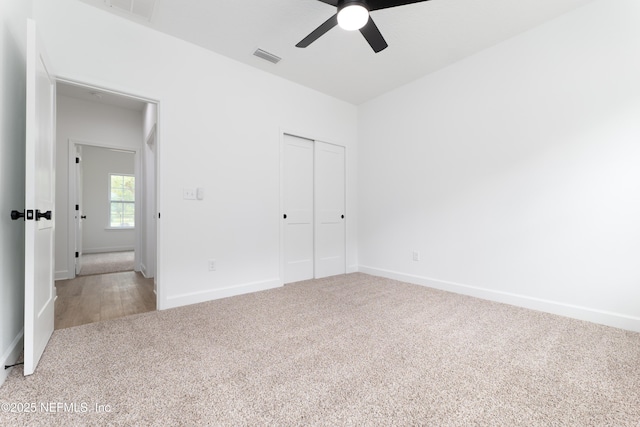 unfurnished bedroom with light carpet, a closet, and ceiling fan