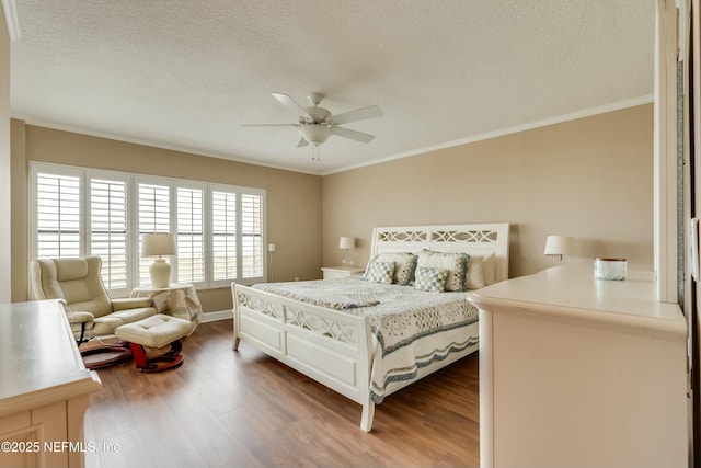 bedroom featuring hardwood / wood-style flooring, ornamental molding, and a textured ceiling