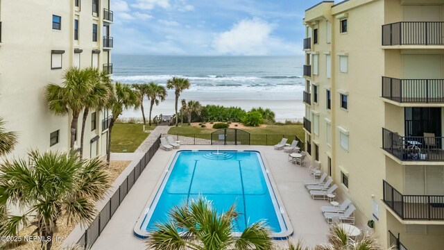 view of swimming pool featuring a patio and a water view