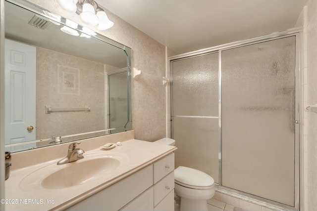 bathroom with an enclosed shower, vanity, and toilet