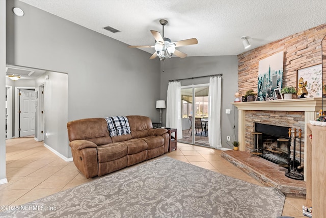 living room featuring lofted ceiling, light tile patterned floors, a textured ceiling, and ceiling fan