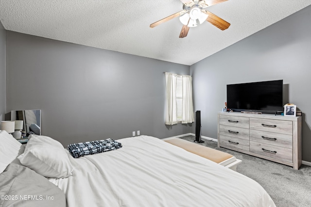 carpeted bedroom with lofted ceiling, a textured ceiling, and ceiling fan