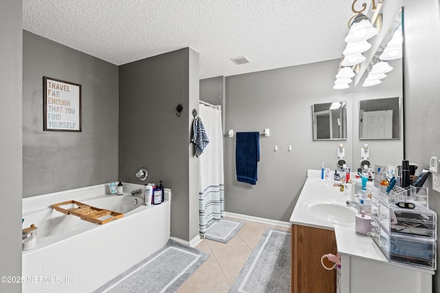 bathroom with a washtub, vanity, tile patterned floors, and a textured ceiling