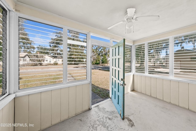 unfurnished sunroom with ceiling fan