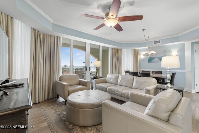 living room featuring crown molding, ceiling fan with notable chandelier, and hardwood / wood-style floors