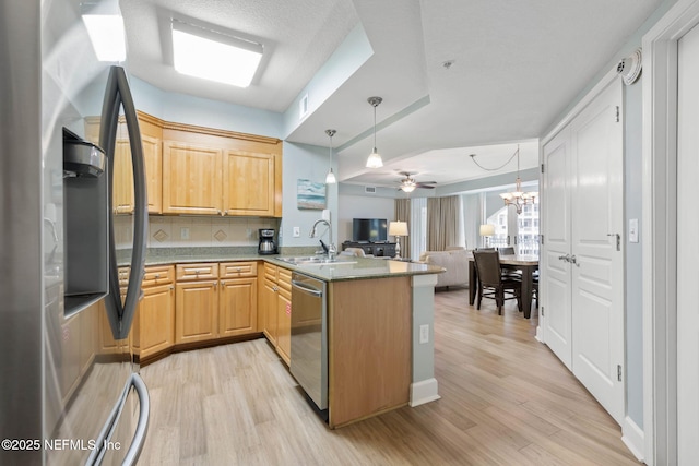 kitchen featuring sink, tasteful backsplash, light brown cabinets, kitchen peninsula, and stainless steel appliances