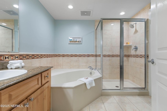 bathroom featuring vanity, separate shower and tub, tile patterned flooring, and tile walls