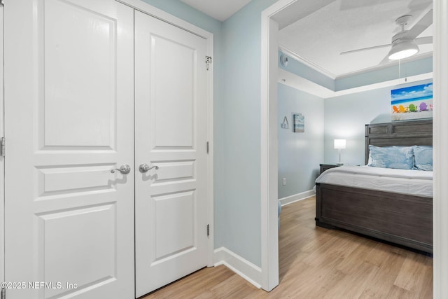 bedroom featuring a textured ceiling, a closet, ceiling fan, and light wood-type flooring