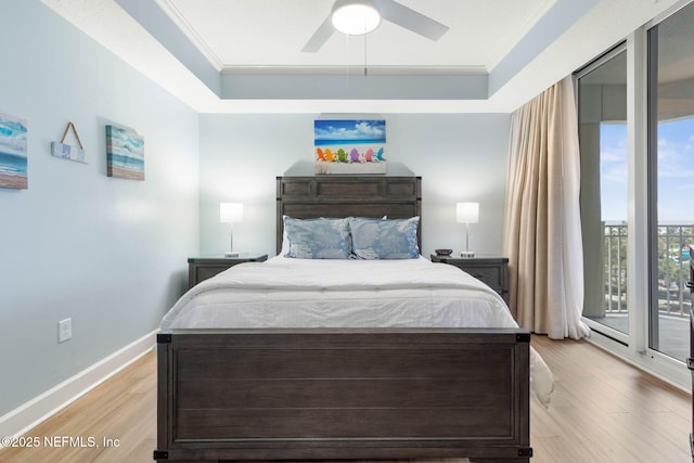 bedroom with crown molding, light hardwood / wood-style flooring, a raised ceiling, ceiling fan, and access to exterior