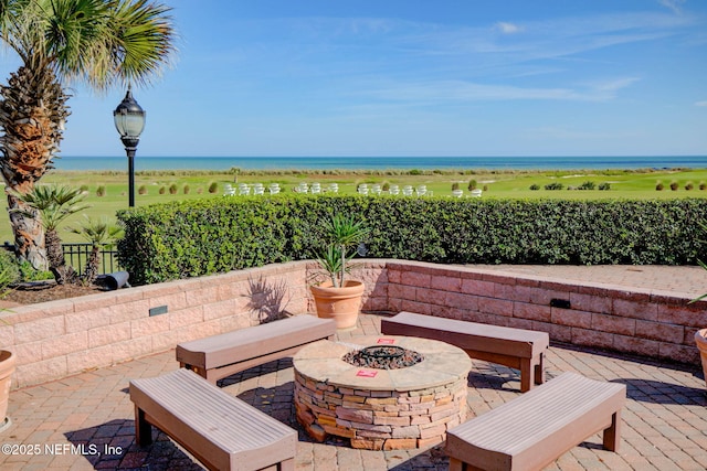 view of patio / terrace with a water view and an outdoor fire pit